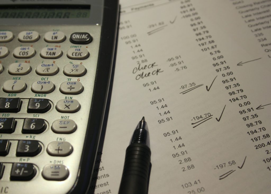 Calculadora, papel e caneta para calcular o ICMS sobre vendas.