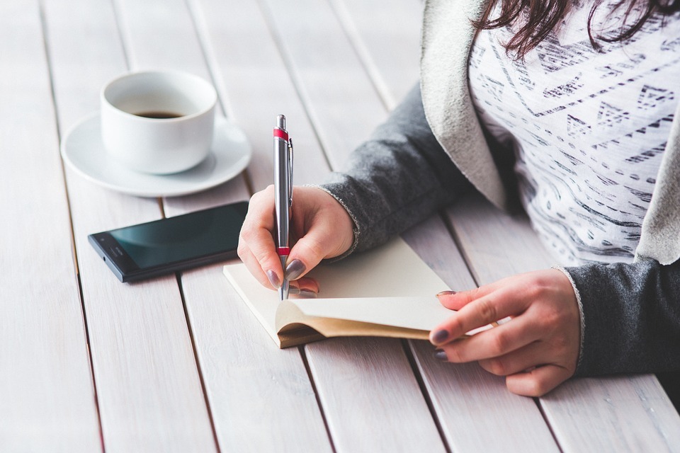 Mulher preenchendo o livro de registro de empregados de sua empresa.