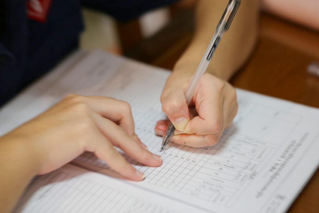 imagem de duas mãos sobre uma planilha, organizando-se com os dados de passivo financeiro