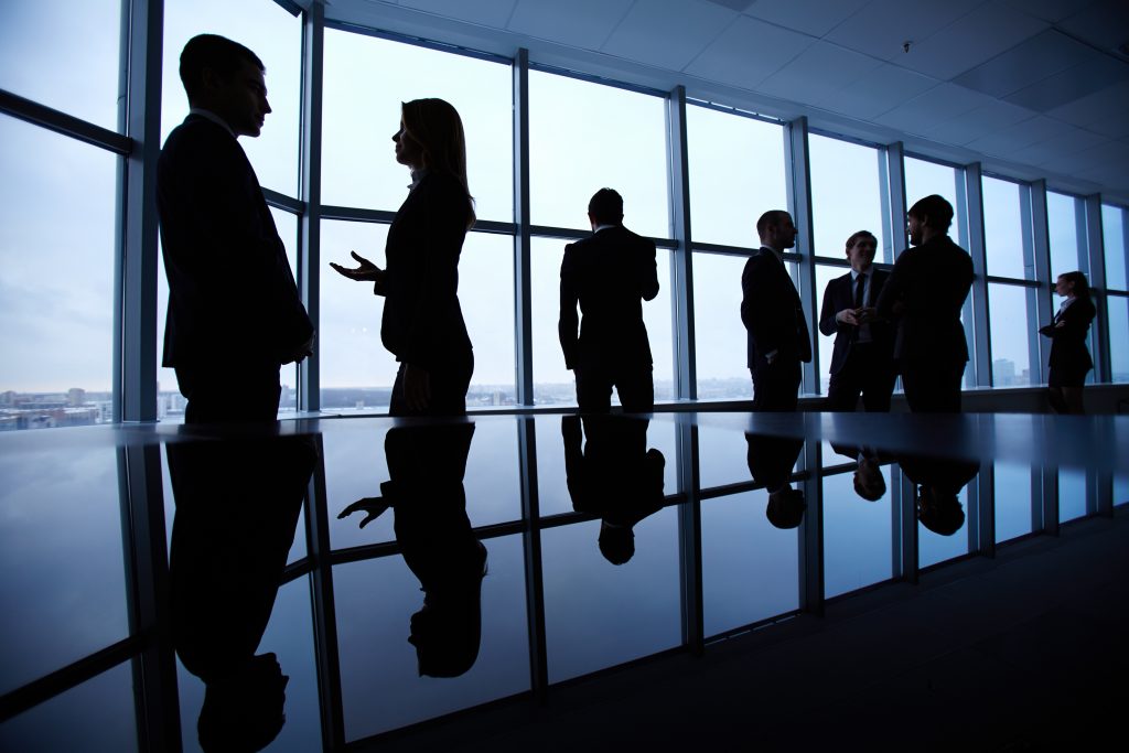 Colegas de trabalho conversando em frente a janela do escritório