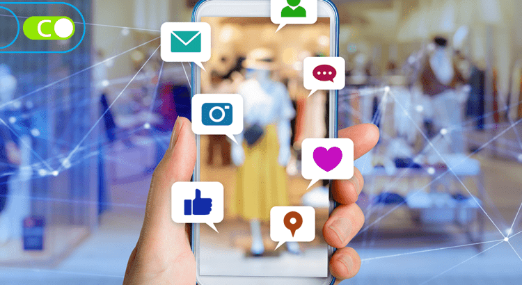 Uma imagem ilustrativa de uma mão segurando um celular, e do celular sai alguns ícones de rede sociais.